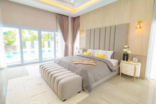Un dormitorio con una cama grande y una ventana grande. en Siam Pool Villa, Pattaya, en Na Jomtien