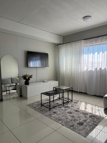 a living room with a table and a couch at Haven at Merensky in Windhoek