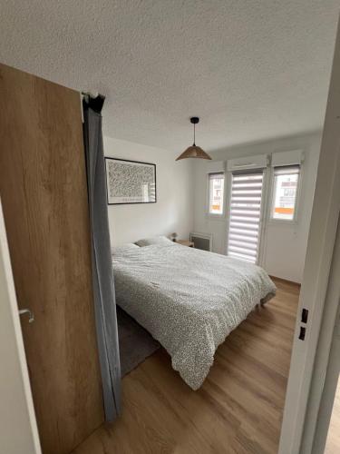 a bedroom with a bed and a wooden floor at Spacieux et confortable - centre ville de BRIANCON - SERRE-CHEVALIER - Garage et Wifi in Briançon