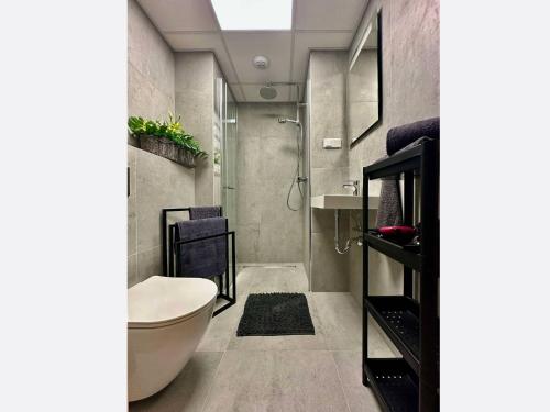 a bathroom with a shower and a toilet and a sink at Jungle Apartment in Krakow