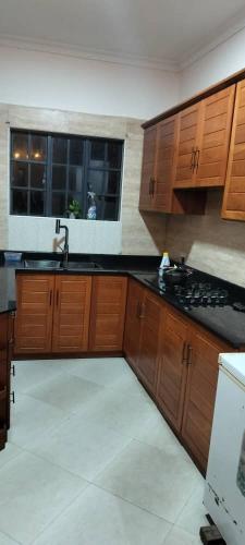 a kitchen with wooden cabinets and a sink and a window at Luxury Peace House in Arusha