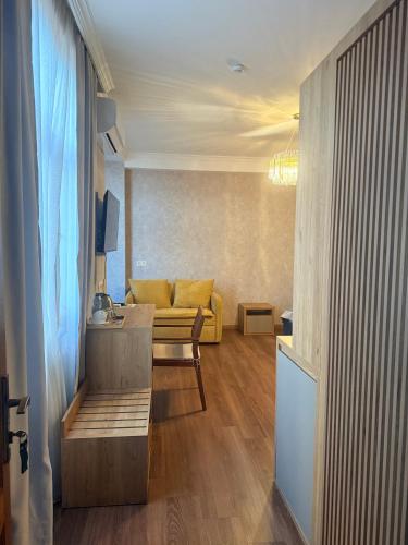 a living room with a yellow couch and a table at Boutique Hotel Tiflis in Tbilisi City