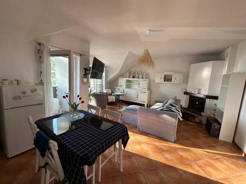 a kitchen and a living room with a table and chairs at Apartament nad jeziorem w Charzykowach in Charzykowy