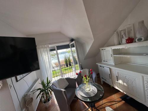 a living room with a table and a television at Apartament nad jeziorem w Charzykowach in Charzykowy