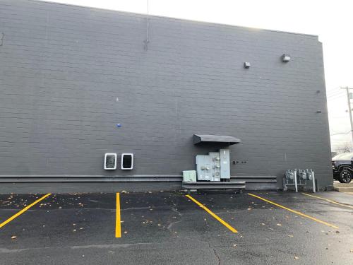 a large gray wall with three windows in a parking lot at The 419 Ten-room Boutique In Sandusky in Sandusky