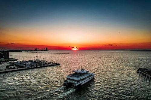 a boat in the water with the sunset in the background at The 419 Ten-room Boutique In Sandusky in Sandusky