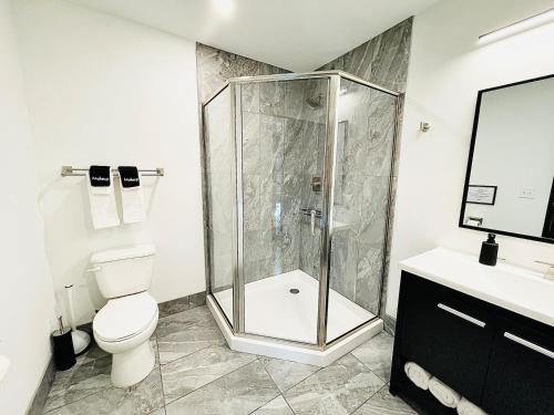a bathroom with a shower and a toilet and a sink at The 419 Ten-room Boutique In Sandusky in Sandusky