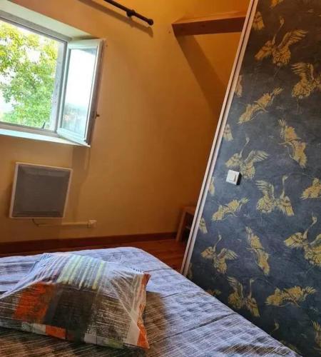une chambre avec un lit et une fenêtre dans l'établissement Maison familiale à Faycelles avec terrasse, à Faycelles