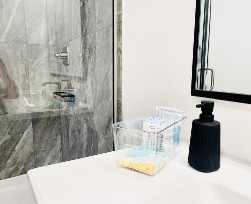 a bathroom counter with a container of toothpaste and a shower at The 419 Ten-room Boutique In Sandusky in Sandusky