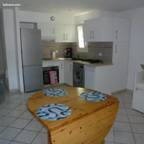 une cuisine avec une table en bois au milieu dans l'établissement Appartement Confortable à Proximité de la Mer 45 m², à Hyères