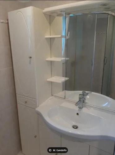 une salle de bain blanche avec un lavabo et un miroir dans l'établissement Appartement Confortable à Proximité de la Mer 45 m², à Hyères