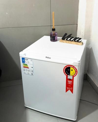 a white refrigerator with a bottle on top of it at Pousada Lemon Suítes - Praia do Sesc Acesso Vista Linda e Centro in Bertioga