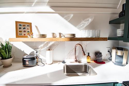 a kitchen with a sink and a shelf with dishes at Oak Hollow in McArthur