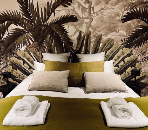 une chambre avec un grand lit avec des serviettes dessus dans l'établissement Chateau et piscine privé près du Chateau de Chambord, à Lanthenay