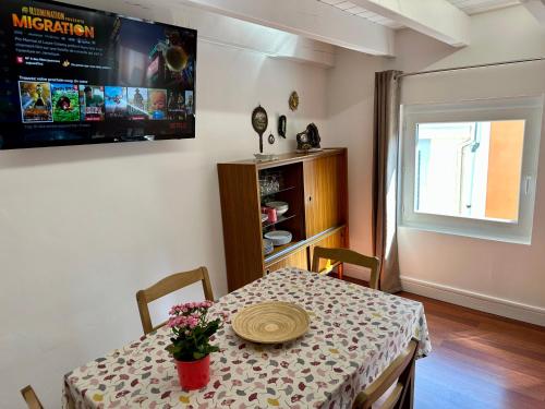 une salle à manger avec une table et une télévision au mur dans l'établissement La Terrasse de Bernadette, à Lourdes