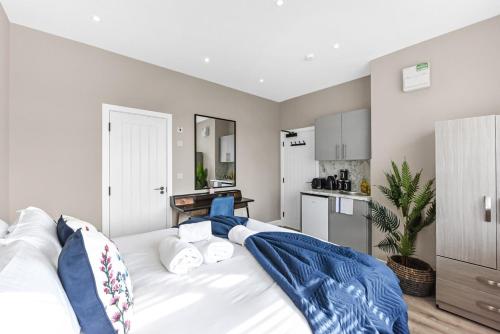 a large white bed in a room with a kitchen at Studio Society - Stay, Cook, and Connect in Southend-on-Sea