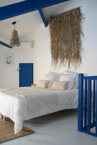 une chambre avec un grand lit avec une tête de lit bleue dans l'établissement Casaïa - Santorin - Chambre avec salle de bain privée, à Hyères
