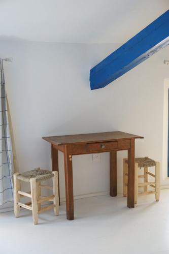une table en bois avec deux chaises et une poutre bleue dans l'établissement Casaïa - Santorin - Chambre avec salle de bain privée, à Hyères