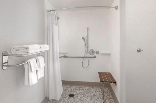 a white bathroom with a shower with towels at Courtyard Palo Alto Los Altos in Palo Alto