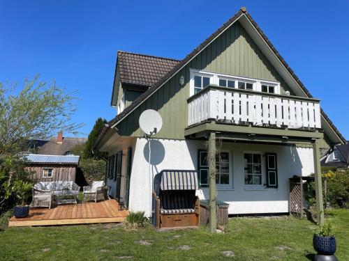 a house with a white balcony and a deck at Ferienhaus Schiffchen "Unter Deck" in Prerow