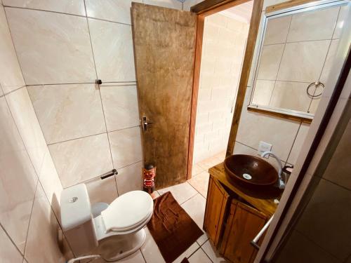 a small bathroom with a toilet and a sink at Loft no Morro da Borussia I in Osório
