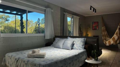 a bedroom with a bed with a large window at Loft no Morro da Borussia I in Osório