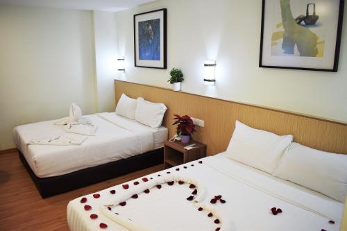 a hotel room with two beds with a valentines bow on them at Xpeed Holiday Hotel in Kuala Lumpur