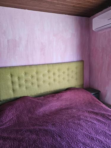 a bedroom with a bed with a purple blanket at Casa in Ciudad de la Costa