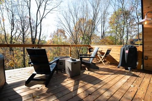 a deck with chairs and a table and a television at Oak Hollow in McArthur