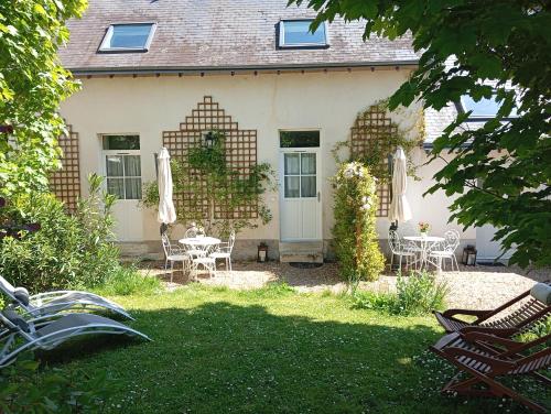 a house with a table and chairs in the yard at Les Charmilles in Amboise