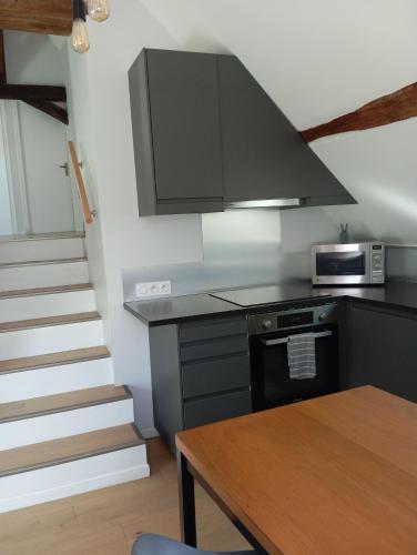 a kitchen with a stove and a microwave at Les Charmilles in Amboise