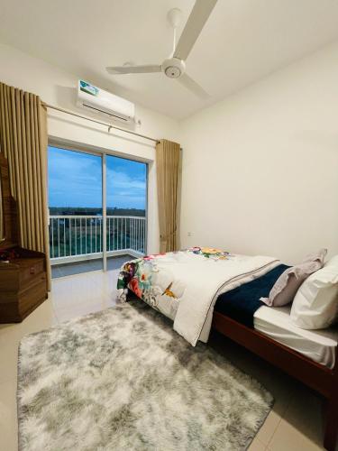 a bedroom with a bed and a large window at Sun Sky Negombo Serviced Apartment in Negombo