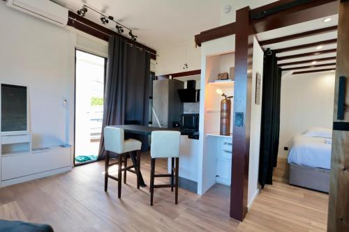 une pièce avec une table, des chaises et un lit dans l'établissement L'Atelier - Apt 2 Prs vue Mer - Clim - parking, à Vallauris