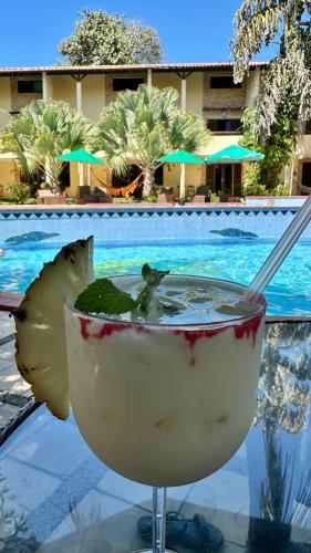 a drink sitting on a glass table next to a pool at Solar de Pipa Prime - Frente piscina in Pipa