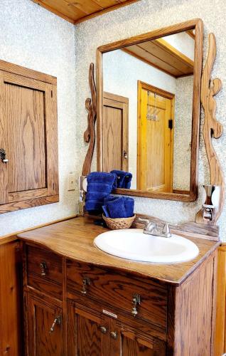 a bathroom with a sink and a large mirror at Cowboy's Trail with HotTub, King&QueenBed, in UpperCanyon, Pets welcome in Ruidoso