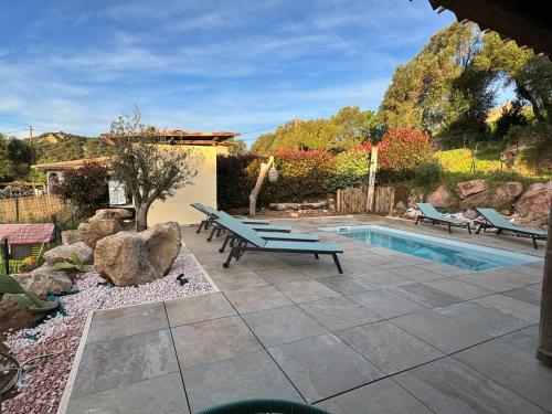 un patio avec un banc et une piscine dans l'établissement A l'Ombra Di l'Alivu, à Figari