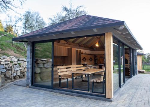 a gazebo with a table and benches at Cabana VeMont in Petru Vodă