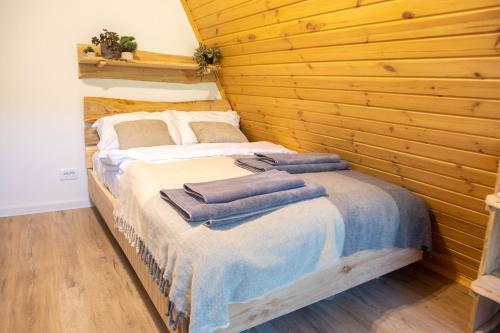 a bedroom with a bed with towels on it at Cabana VeMont in Petru Vodă