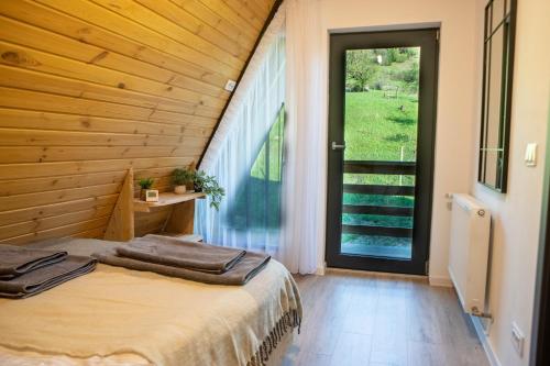 a bedroom with a bed and a large window at Cabana VeMont in Petru Vodă