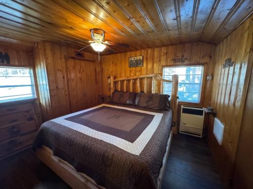 a bedroom with a bed in a wooden cabin at Cowboy's Trail with HotTub, King&QueenBed, in UpperCanyon, Pets welcome in Ruidoso