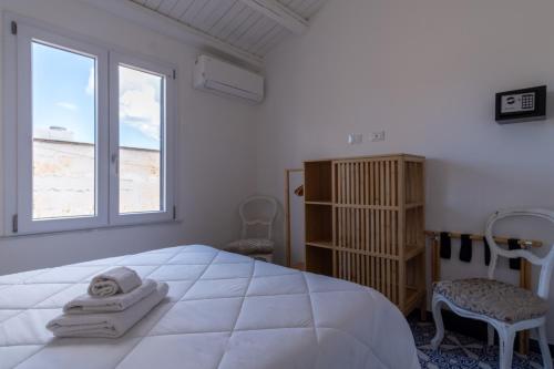 a bedroom with a large white bed and a window at Zisa Top Romantic Terrace & Private outdoor Jacuzzi in Palermo