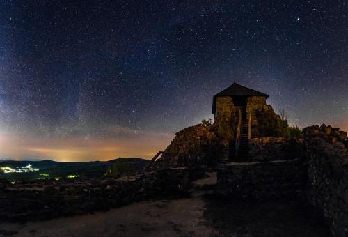 a night view of a building on top of a mountain at SB Sport Apartman in Salgótarján