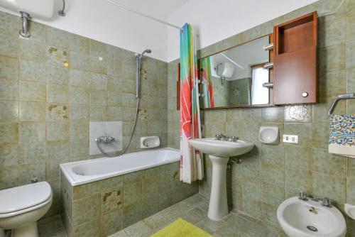 a bathroom with a sink and a toilet and a bath tub at Casa Vacanza Costa del Sole in Pomonte