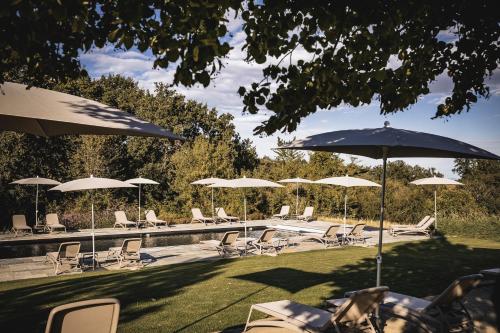 a group of chairs and umbrellas next to a pool at Locanda Cossetti Ranch Winery in Incisa Scapaccino
