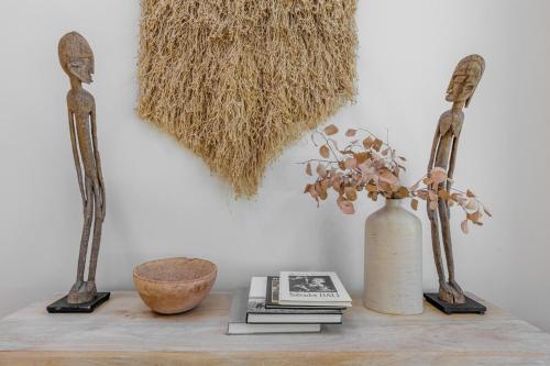 a table with two sculptures and a book and a vase at L'Escape Joshua Tree in Joshua Tree