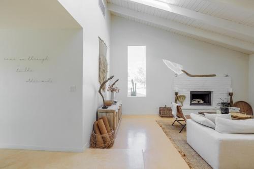 a living room with a white couch and a fireplace at L'Escape Joshua Tree in Joshua Tree