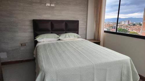 a bed with two pillows in a room with a window at Beautiful and central apartment in Tarija