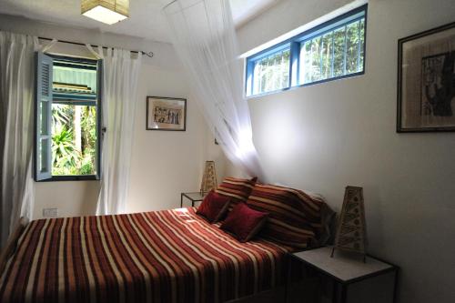 a bedroom with a bed and two windows at Harmony Villa in Pont Cassé