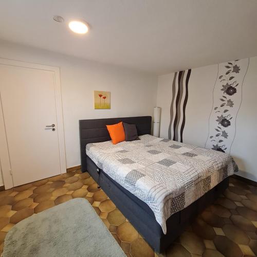 a bedroom with a bed with an orange pillow on it at Ferienhaus am Fuchsberg in Dahme