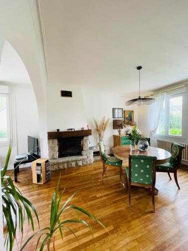un salon avec une table et des chaises et une cheminée dans l'établissement La Grande Plage, tout proche des plages, 5 personnes, à Plestin-les-Grèves